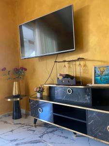 een televisie aan een muur met een blauw dressoir bij Appartamento feriolo Margherita in Baveno