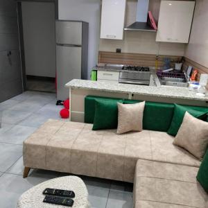 a living room with a couch in front of a kitchen at Super Chiraz Loft in Nabeul