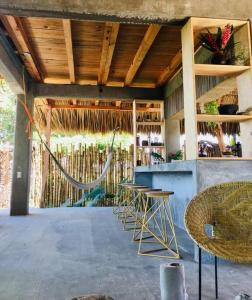 a bar with chairs and a hammock in a building at Peaceful beachside artist-designed in Puerto Escondido
