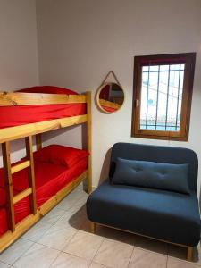 a room with two bunk beds and a blue couch at CORALINES - Villa en residence in Saint-Cyprien