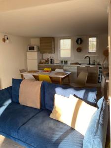 a living room with a blue couch in a kitchen at CORALINES - Villa en residence in Saint-Cyprien