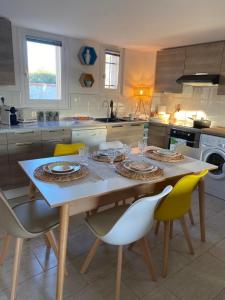 a kitchen with a wooden table with chairs and a tableablish at CORALINES - Villa en residence in Saint-Cyprien