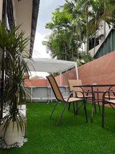 a patio with a table and chairs and palm trees at D Riad Ipoh Homestay l Home Cinema l 300MBPS in Ipoh