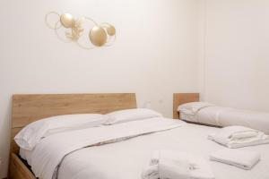 a bedroom with three beds with white sheets at BnButler - Pellegrino Rossi, 42 - Ampio e Comodo per 5 in Milan