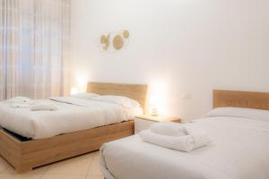 um quarto com 2 camas e lençóis brancos em BnButler - Pellegrino Rossi, 42 - Ampio e Comodo per 5 em Milão