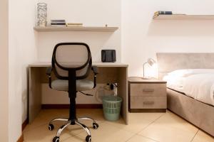 um quarto com uma secretária e uma cadeira ao lado de uma cama em BnButler - Pellegrino Rossi, 42 - Ampio e Comodo per 5 em Milão