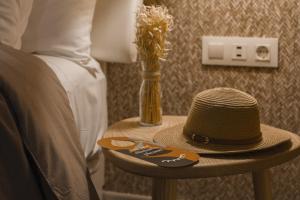 un sombrero sentado en una mesa junto a una cama en room Select Tetuán, en Sevilla