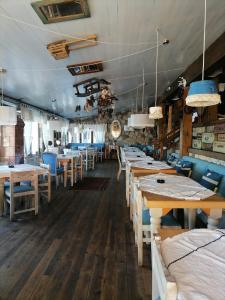 un comedor con mesas de madera y sillas azules en Nela apartmani (u hotelu Djina), en Kopaonik