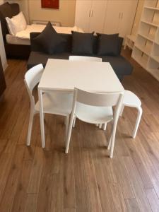 a white table and chairs in a living room at Savenella Apartments in Bologna