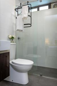ein Bad mit einem WC und einer Glasdusche in der Unterkunft Moonee Ponds’ hidden gem – 1BR w/ Free Parking in Melbourne