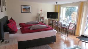 - une chambre avec un lit doté d'oreillers rouges dans l'établissement Apartment Christine, à Altena