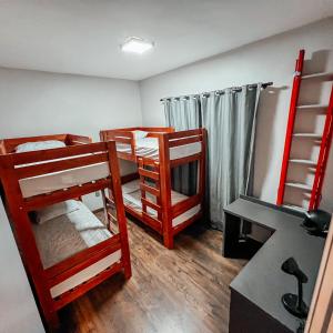 彼得羅波利斯的住宿－Casa Recanto da Neblina，客房设有两张双层床和一张书桌。