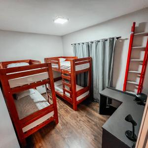 a room with two bunk beds and a desk at Casa Recanto da Neblina in Petrópolis