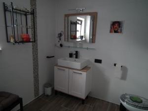 a bathroom with a white sink and a mirror at Am Wiesengrund - mit 2 Schlafzimmern in Ribnitz-Damgarten