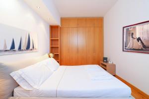 sypialnia z białym łóżkiem i drewnianą szafką w obiekcie Duomo Luxury Apartment VIII w Mediolanie