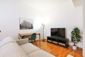salon z kanapą, telewizorem i stołem w obiekcie Duomo Luxury Apartment VIII w Mediolanie