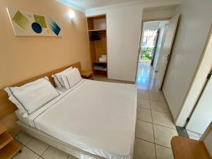 a bedroom with a large white bed with white pillows at DiRoma Fiori com um dia no Acqua park, Splash e Slide in Caldas Novas