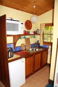 a kitchen with a sink and a microwave at Candlebark Retreat in Beechworth