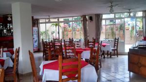 Hotel Real Santa María في كويرنافاكا: مطعم به طاولات وكراسي حمراء وبيضاء
