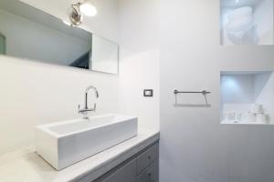 biała łazienka z umywalką i lustrem w obiekcie Duomo Luxury Apartment VIII w Mediolanie +15 zdjęć
