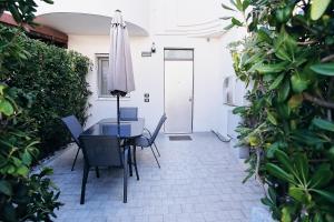 a patio with a table and chairs and an umbrella at Profumo di mare - casa vacanze in Vasto