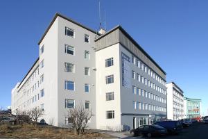 a large white building with cars parked in front of it at Stay Apartments Bolholt in Reykjavík