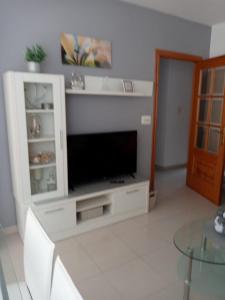 una sala de estar con TV en un armario blanco en Apartamento Combarro Ángeles, en Combarro