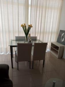 una mesa de comedor con sillas y un jarrón de flores. en Apartamento Combarro Ángeles, en Combarro