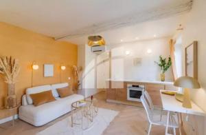 un salon avec un canapé blanc et une table dans l'établissement 2 pièces vieux Nice vue coulée verte, à Nice