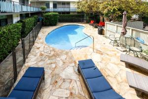 a swimming pool with two lounge chairs next to a building at Honolulu Vacation Rental Walk to Beaches in Honolulu