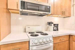 a kitchen with a white stove and a microwave at Honolulu Vacation Rental Walk to Beaches in Honolulu