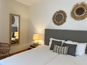 a bedroom with a white bed and a mirror at Pestana Palm Gardens in Carvoeiro