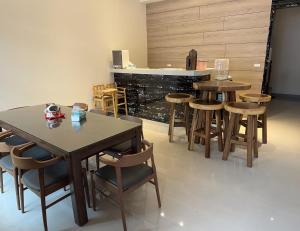 una stanza con due tavoli e sedie e un bar di 山田心溜滑梯民宿 a Chiang-hsi-shan-lin