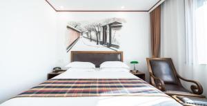- une chambre avec un lit et une chaise dans l'établissement Nostalgia Hotel Beijing - Tian'anmen Square, à Pékin