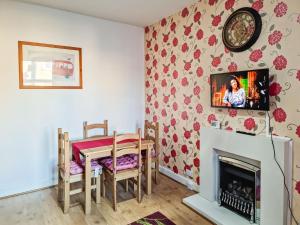 a dining room with a table and a fireplace at Cosy Penicuik Apartment in Penicuik