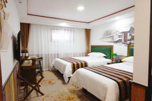 a hotel room with two beds and a television at Nostalgia Hotel Beijing - Tian'anmen Square in Beijing