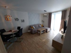 ein Wohnzimmer mit einem Sofa und einem Tisch in der Unterkunft Apartmán Filip - Pod Lesom in Vysoké Tatry