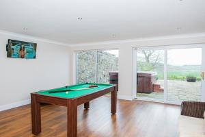 a living room with a pool table in it at Balmeadowside Farmhouse with Hot Tub in Cupar
