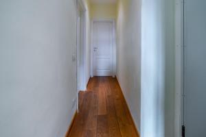 a hallway with a white door and a wooden floor at Florence Quiet Apartment with Private Garden in Florence