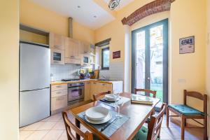 a kitchen with a table and a white refrigerator at Florence Quiet Apartment with Private Garden in Florence