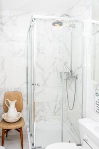 a bathroom with a shower with a toilet and a chair at Eiffel Tower view Residence in Paris