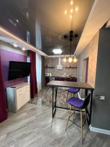 a dining room with a table and purple chairs at Дизайнерская Студио 10 мин метро Позняки in Kyiv