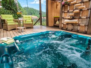 a hot tub on a deck with a table and chairs at Pousada Aguia Dourada in Monte Verde