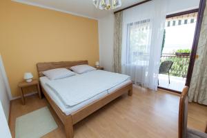 a bedroom with a bed and a large window at Villa Lesic in Dramalj