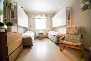 1 dormitorio con 2 camas, silla y ventana en Skellefteå Camping en Skellefteå