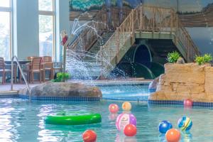 a swimming pool with a waterfall and a slide at Arrowwood Lodge at Brainerd Lakes in Baxter