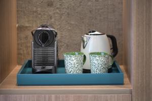 a toaster and two cups on a shelf at Querencia de Sevilla, Autograph Collection in Seville