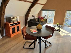 a living room with a table and chairs and a microwave at De Haven in Zierikzee