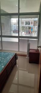 ein Schlafzimmer mit einem Bett und einem großen Fenster in der Unterkunft My Flat in Praia