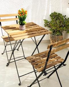ein Holztisch und ein Stuhl mit Blumen drauf in der Unterkunft Pninat Hadrom in Be’er Scheva